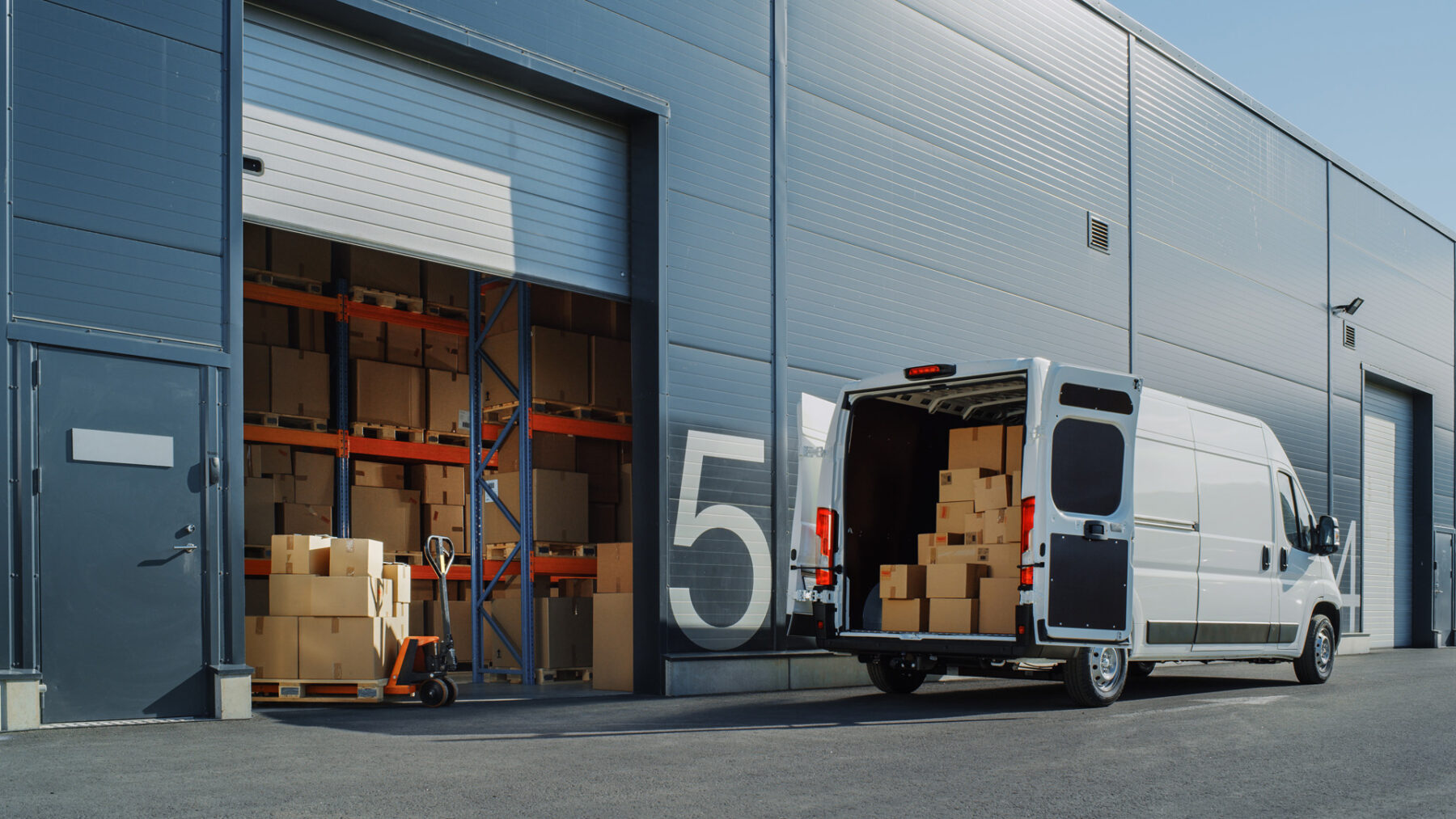 Outside of Logistics Warehouse with Open Door, Delivery Van Load